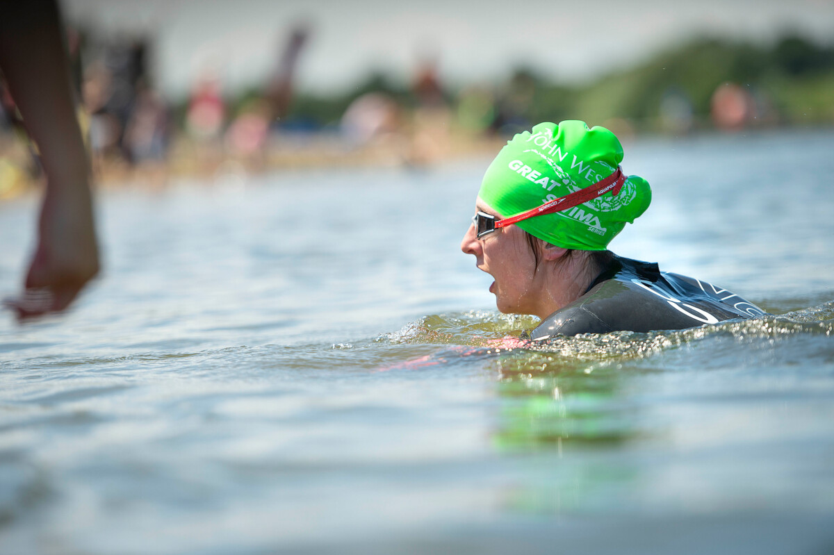 A woman wearing goggles and a wetsuit doing open water swimming