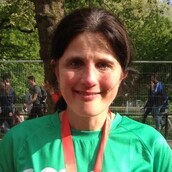 A woman wearing a green Macmillan t-shirt at the London Marathon
