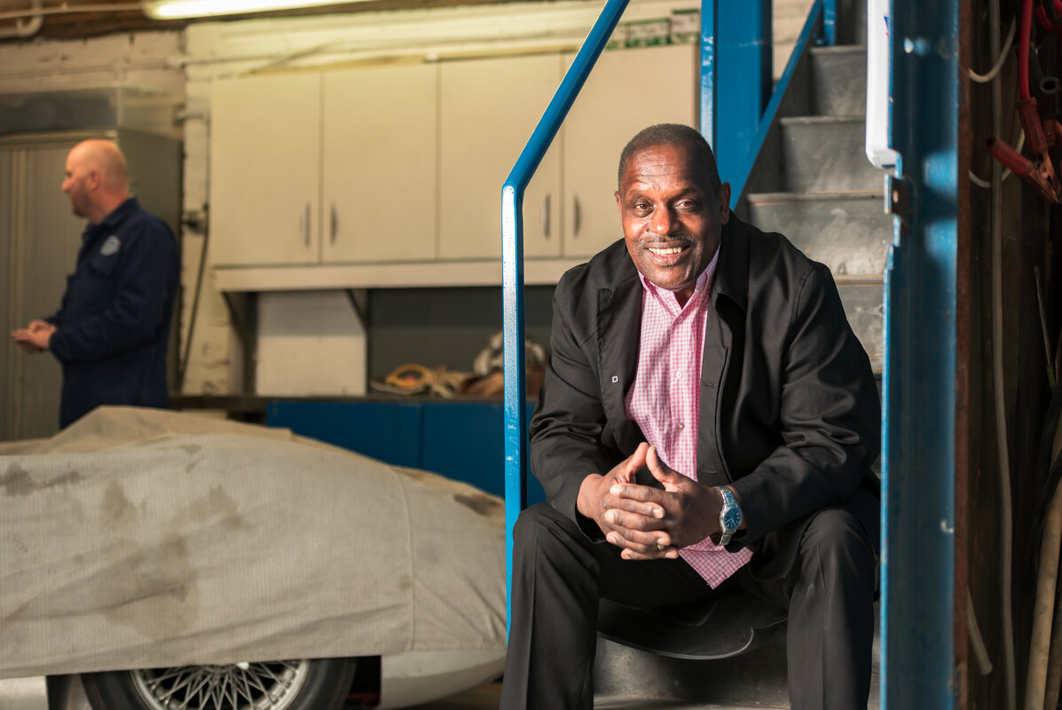 Errol, diagnosed with prostate cancer, sitting on some steps in a garage.