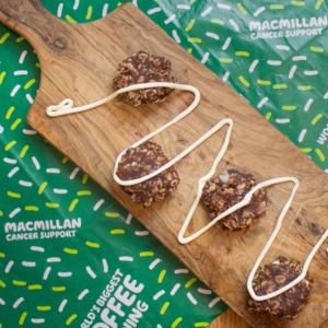 Cookies with coconut cream drizzled on top on a wooden board