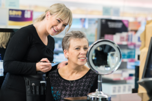 A Boots beauty adviser showing a woman make-up techniques
