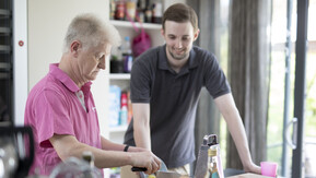 Two men prepare cooking ingredients in the kitchen.
