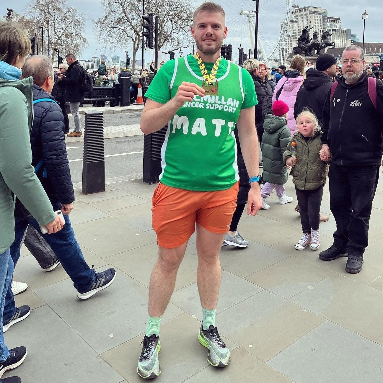 Matt, a white male in running shorts and t shirt with a running medal.