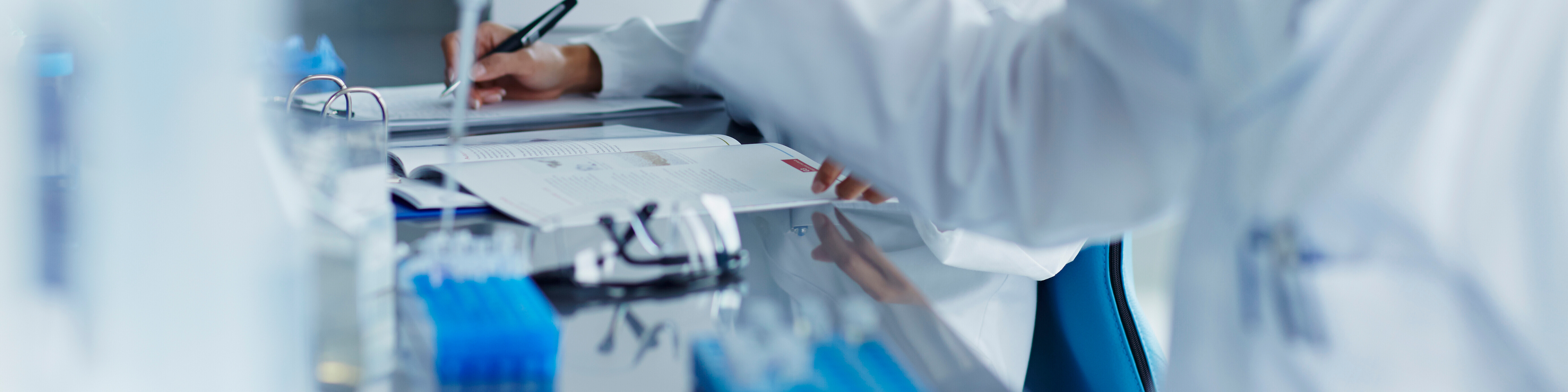 scientists in white lab coats working in a lab.