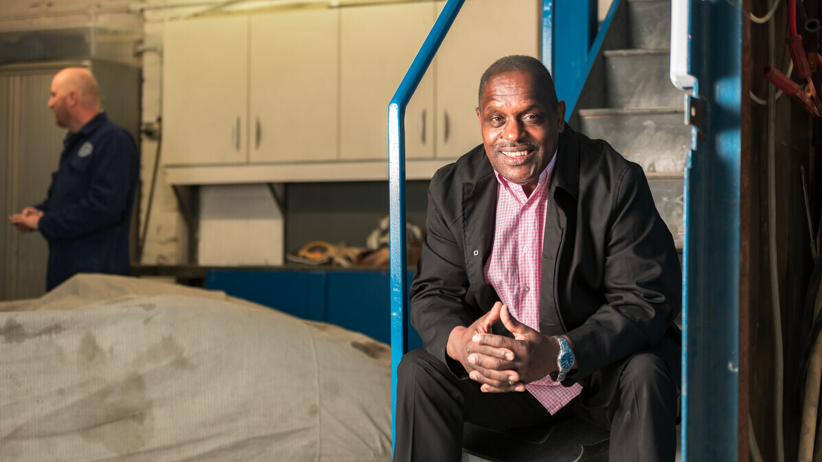 Errol, diagnosed with prostate cancer, sitting on some steps in a garage.