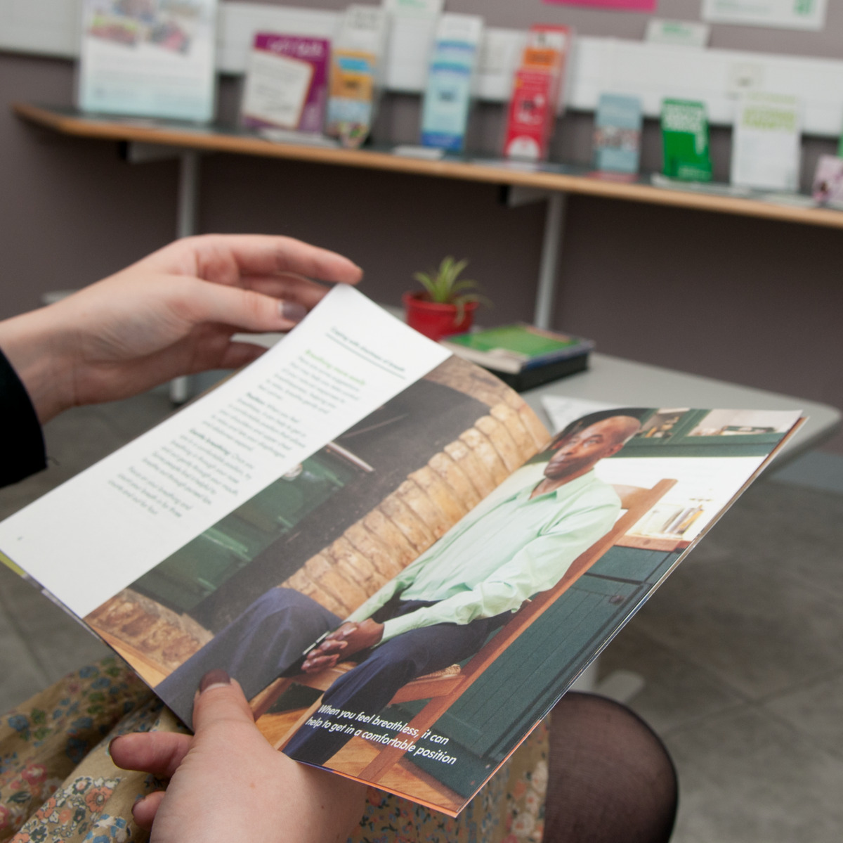 A person reading a book in a Macmillan Support Centre. 