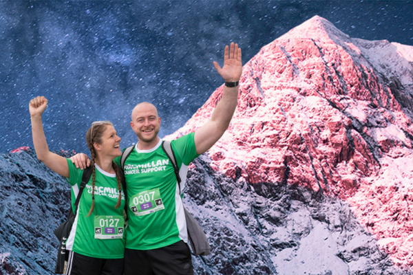 A man and woman wearing Macmillan t-shirts with the image of a mountain in the background