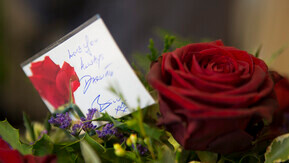 A red rose with a tribute card