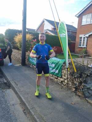 Simon giving a thumbs up off of the bike on the pavement 