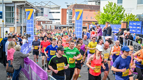 A large group of runners running through the streets of a city