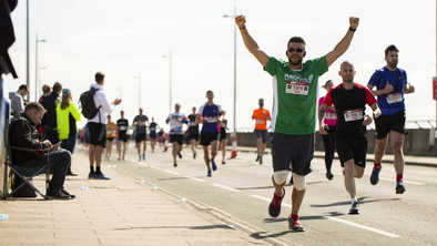 Macmillan runner with his arms raised above his head