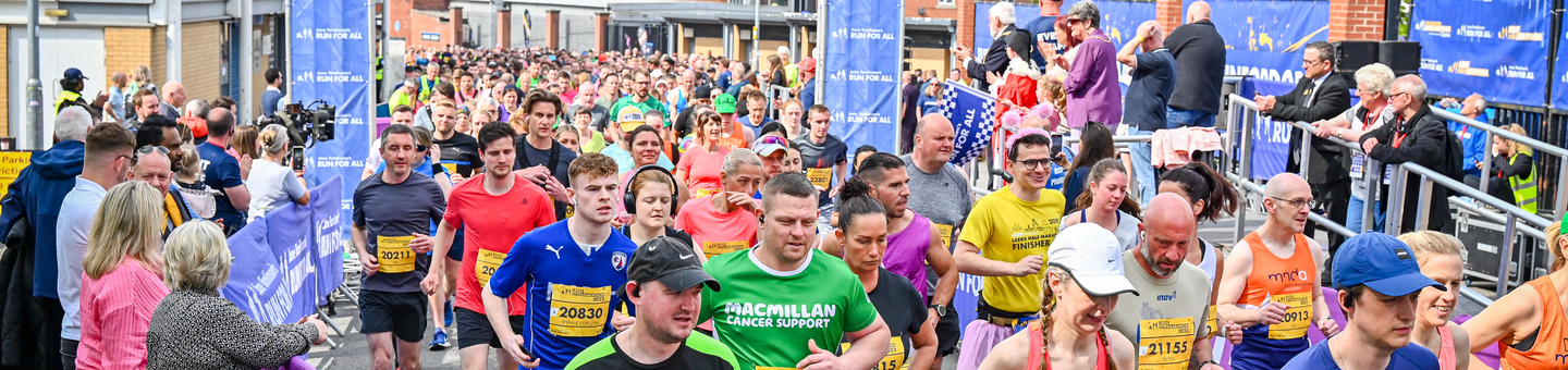 A large group of runners running through the streets of a city