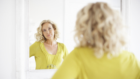 A woman looking at herself in a mirror