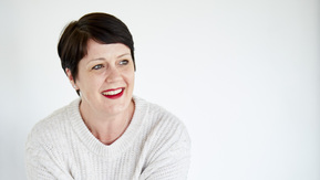 A woman sitting casually on a bench in a gym
