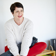 A woman sitting casually on a bench in a gym