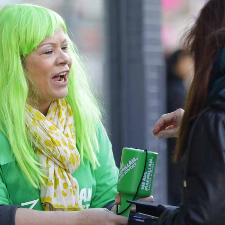 A woman with green hair collecting money for Macmillan on the street