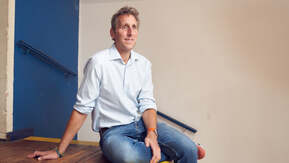 A man casually sitting on a top step