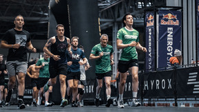 A group of people taking part in an indoor fitness event.