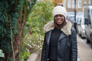 Shola on the street smiling.