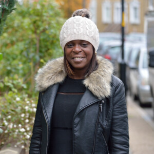 Shola on the street smiling.