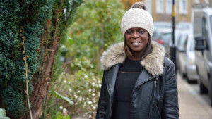 Shola on the street smiling.