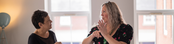 Two women are having a conversation using British Sign Language