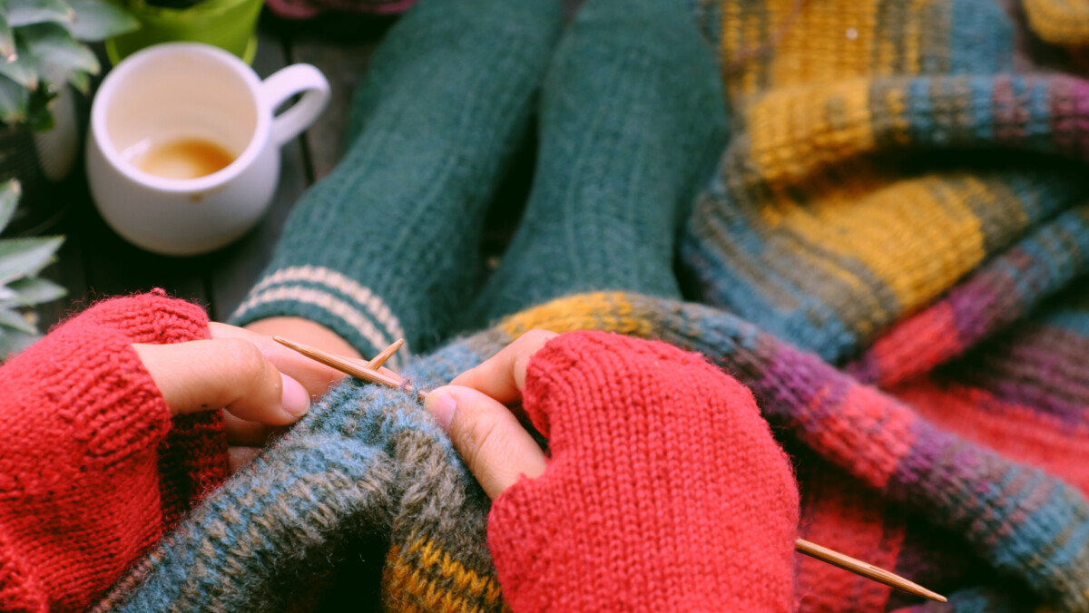 Person in fingerless gloves knitting