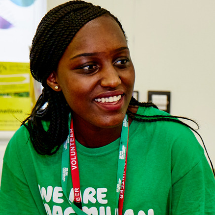 A Macmillan volunteer wearing a green Macmillan T-shirt