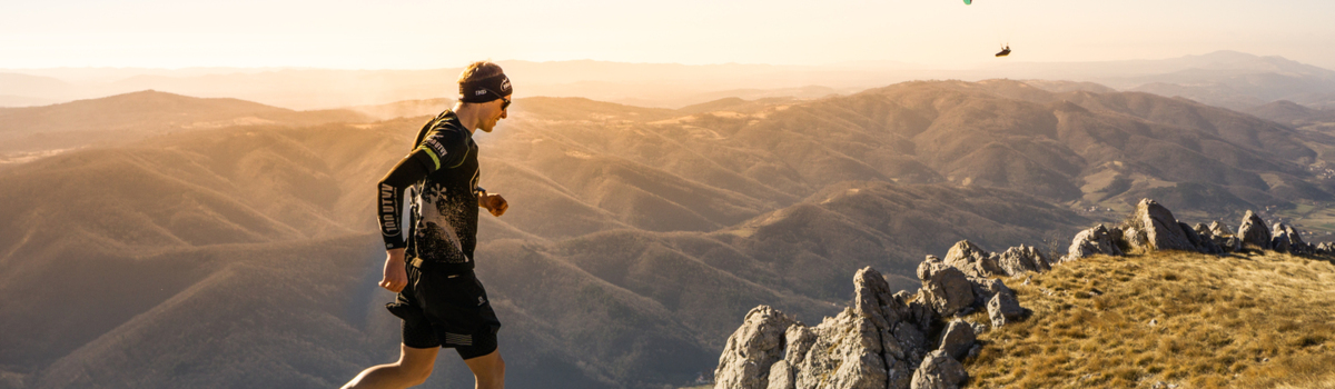 An Ultra X series competitor running on hilly, mountainous terrain.