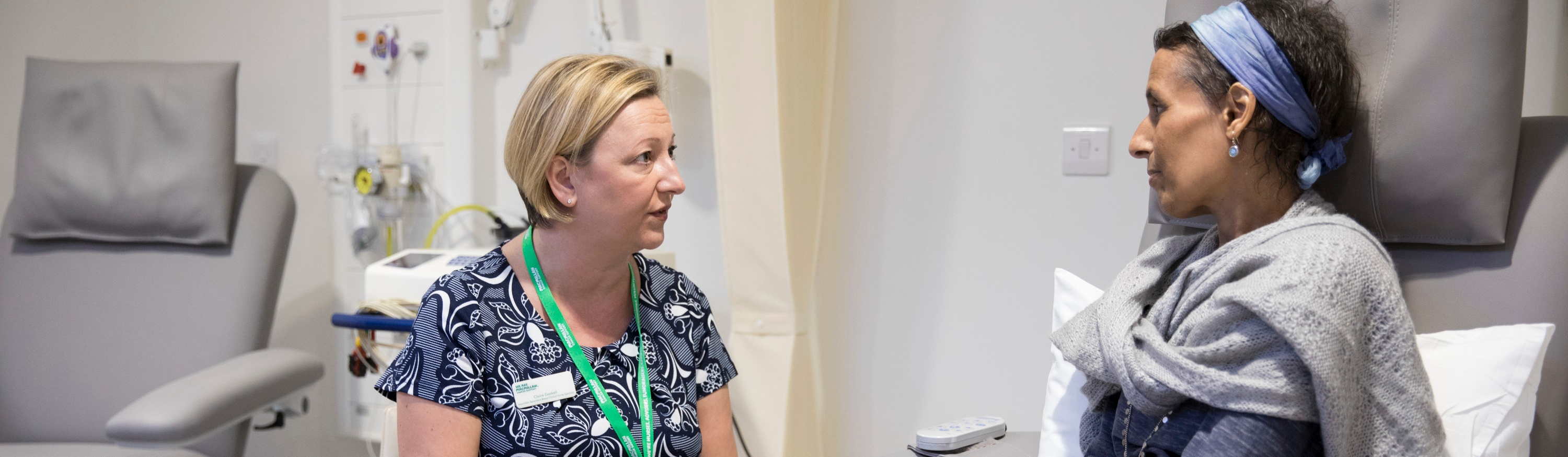 A Macmillan nurse talking to a woman in a hospital setting