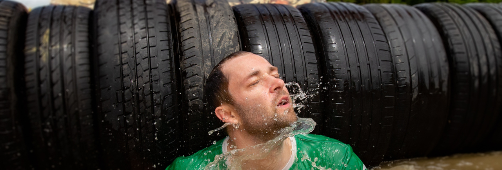 Man emerging from under tires in the water