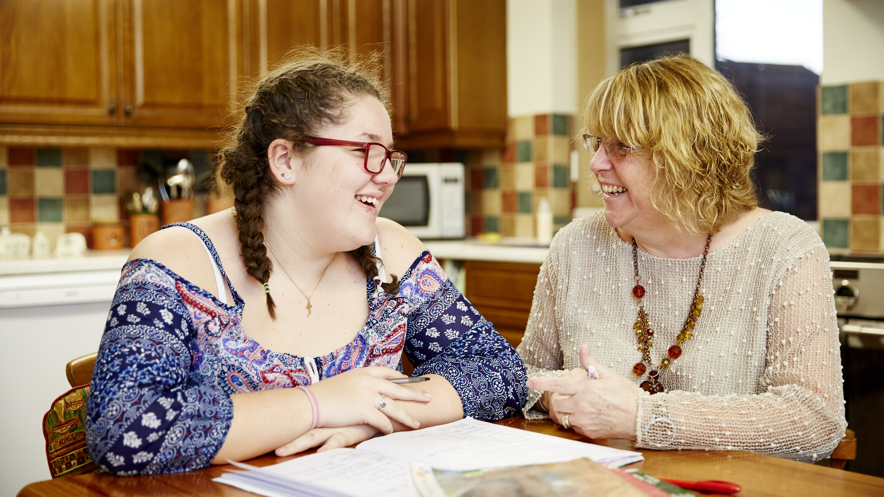 Grace sitting at the kitchen table with her mum