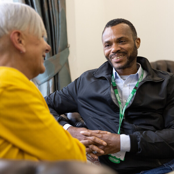 Macmillan employee talking to woman in yellow jumper