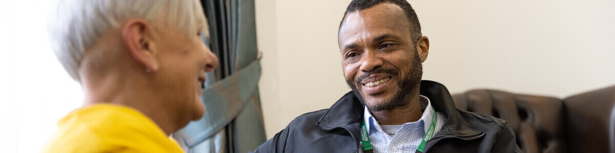 Macmillan employee talking to woman in yellow jumper