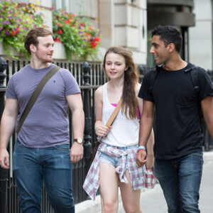 Three young people walking together along the pavement