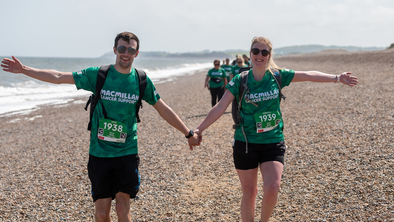 A couple of Mighty Hikers walking hand in hand on the beach
