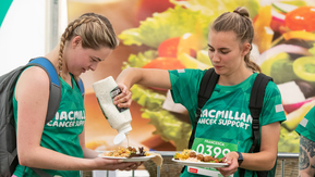 A Mighty Hiker squeezing some sauce over her fellow hiker's food