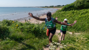 Mighty Hikers walking up a path away from the beach