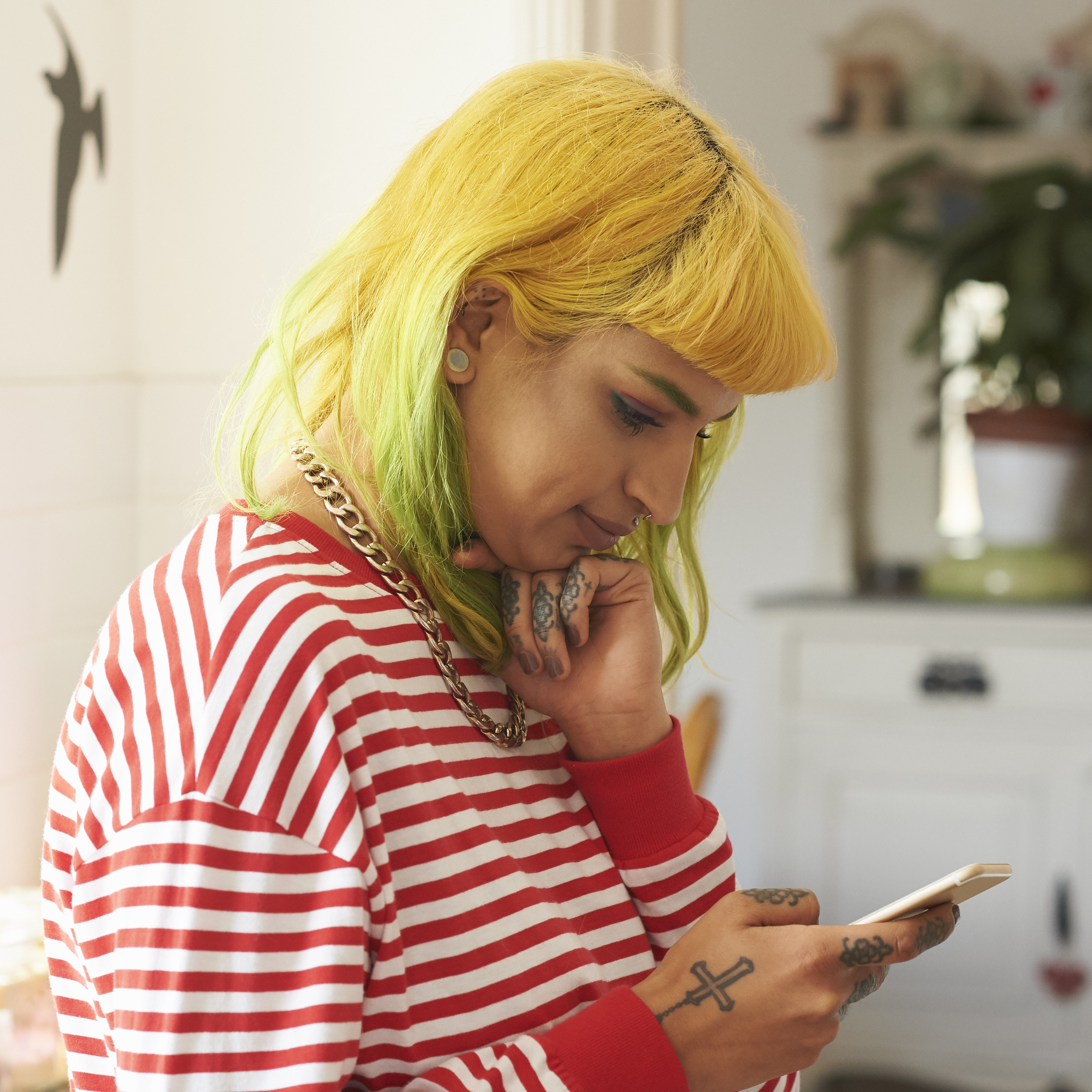 A women with yellow hair looks at her mobile phone.