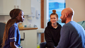 A nurse speaks to a male and female patient.