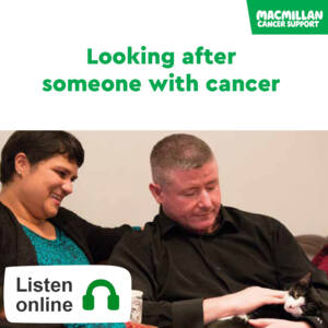 Man and woman sitting on sofa, man is holding a cat