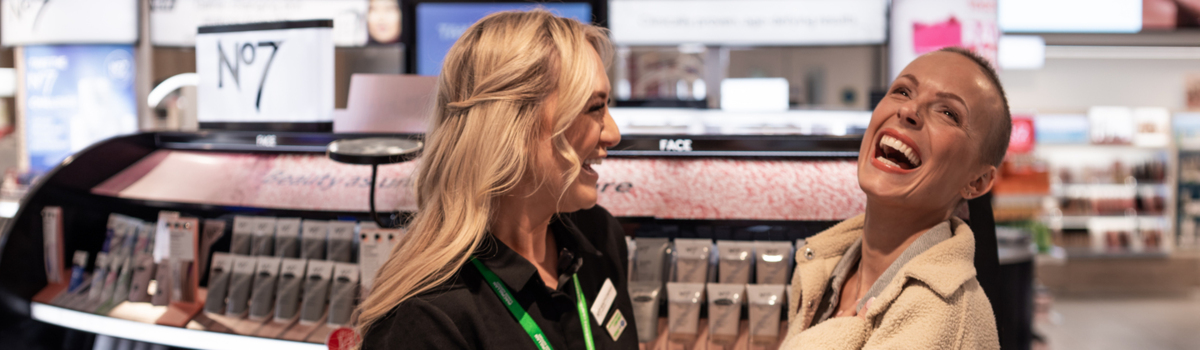 A No7 Boots Macmillan Beauty Advisor is laughing with a customer