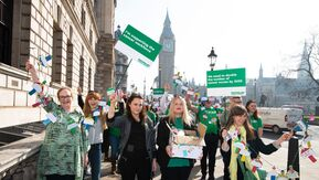Macmillan campaigners stood in the street holding signs