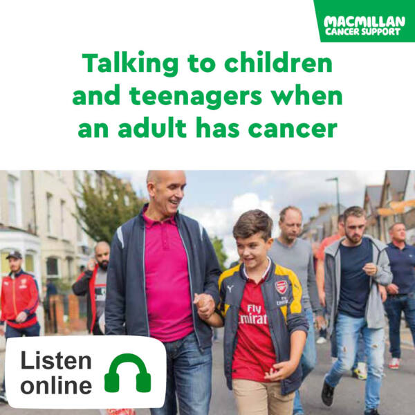 Father holding sons hand while walking down street. They are wearing football shirts.