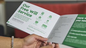 Hands holding a Macmillan brochure with the heading Our Free Will Service