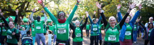 Group of Macmillan runners cheering with their hands in the air