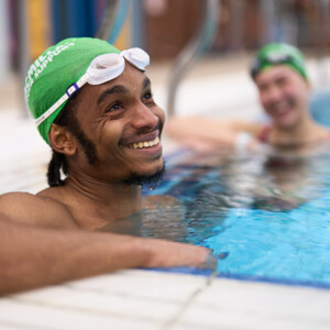 A young black man is in a swimming pool.