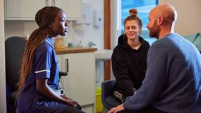 A nurse is talking to a male and female patient.