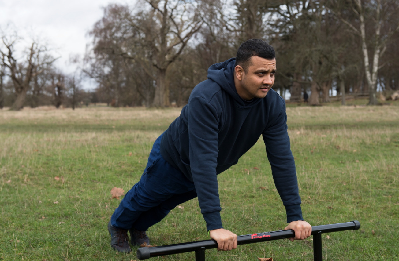 A man doing press-up exercises in a park