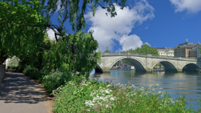 A path alongside the Thames river and a bridge crossing it